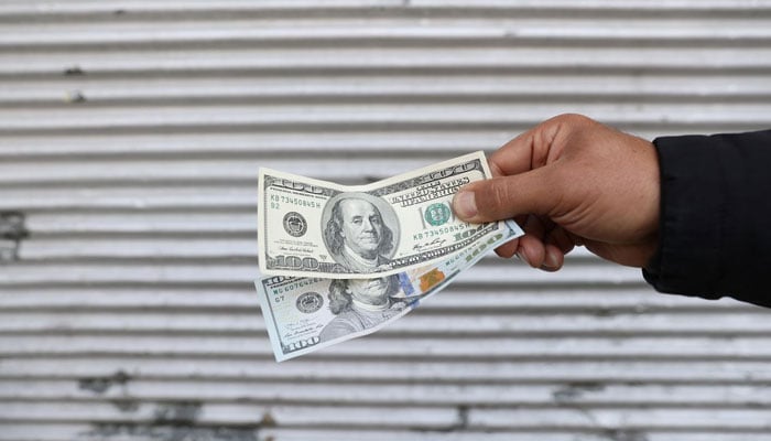 A street-side currency vendor holds US dollars at Ferdowsi Square in Tehran, Iran November 14, 2021.— Reuters/File