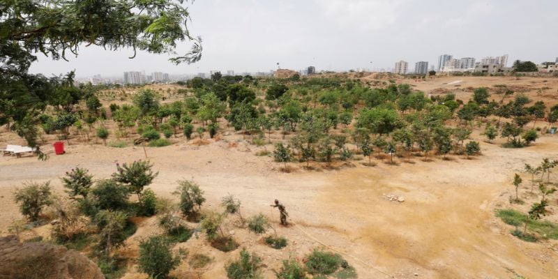 A worker waters a portion of urban forest at Kidney Hill park in Karachi, Pakistan June 3, 2021. In Pakistan, forest cover lags far behind average levels across South Asia. REUTERS