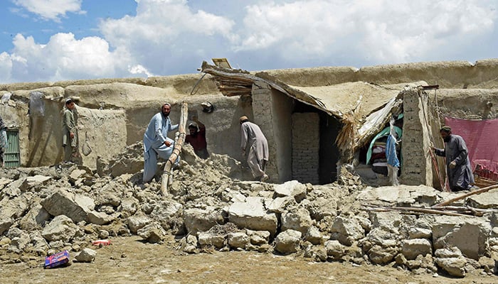Flood-affected residents clear debris after the dam in Pishin district of Balochistan broke due to heavy rains on July 7, 2022. — AFP