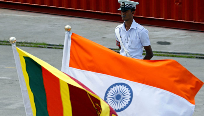 A Navy officer stands in front of Indias and Sri Lankas national flags as Indian Coast Guard Ship (ICGS) Shoor is in the Colombo port during its visit in Colombo, Sri Lanka April 2, 2018. — Reuters