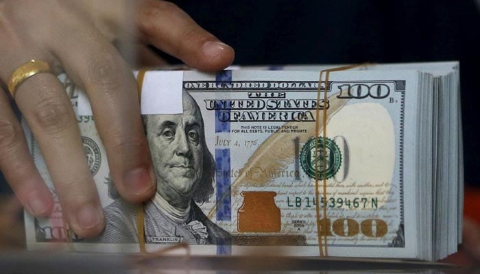 An employee of a money changer holds a stack of U.S. dollar notes before giving it to a customer in Jakarta, October 8, 2015. — Reuters/File