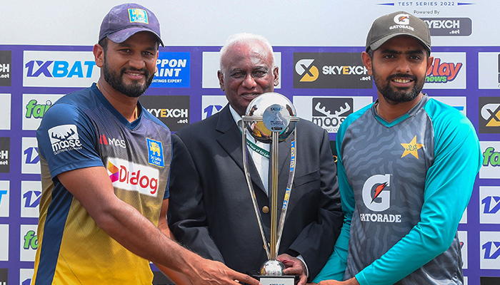 Sri Lankas captain Dimuth Karunaratne (L) and Pakistans captain Babar Azam (R) pose with the Test trophy after Sri Lanka won the second cricket Test match between Sri Lanka and Pakistan at the Galle International Cricket Stadium in Galle on July 28, 2022. — AFP