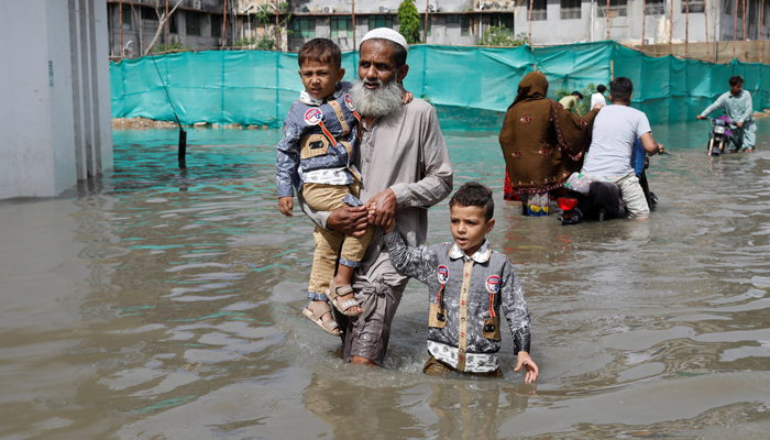 Residents wade through a flooded street during the monsoon season in Karachi, Pakistan July 11, 2022. — Reuters/Akhtar Soomro