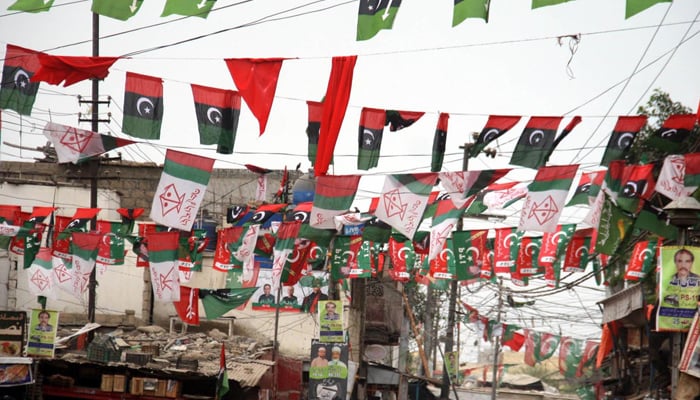 Flags of political parties are displayed at City Railway Colony ahead of General Election 2018. — Online