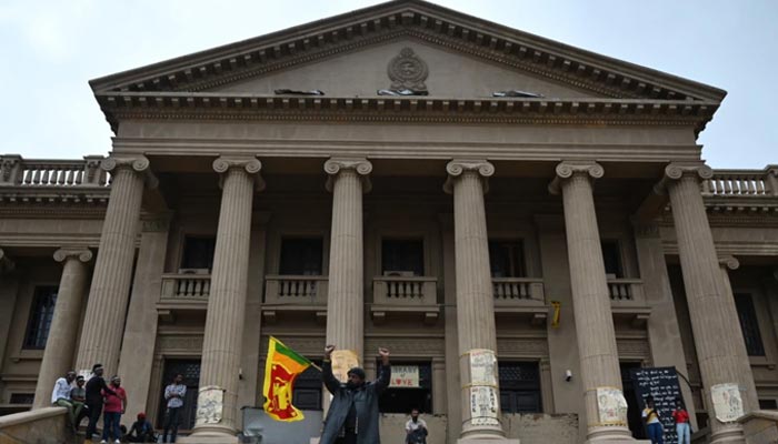 A demonstrator carrying a Sri Lankan national flag gestures in front of the presidential secretariat in Colombo on July 21, 2022. — AFP/File