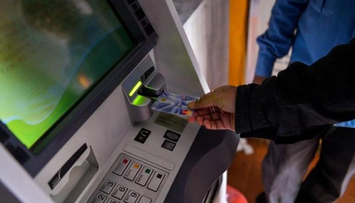 A man inserts his card to withdraw money from a mobile bank ATM machine in New Delhi on November 15, 2016. — AFP/File