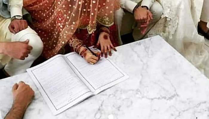 A bride is signing her marriage papers. Photo: Twitter/ShowbizAndNewz/file