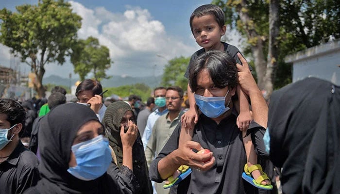 Mourners wearing masks attend a Muharram procession in Pakistan. — AFP