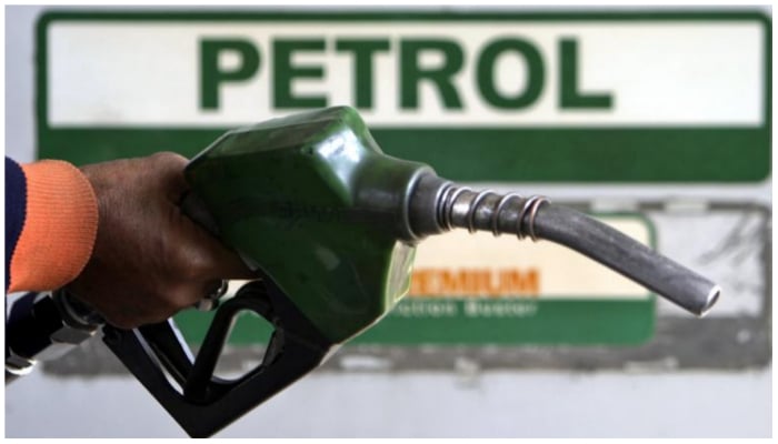 An attendant holds a petrol nozzle at a petrol pump. — Reuters