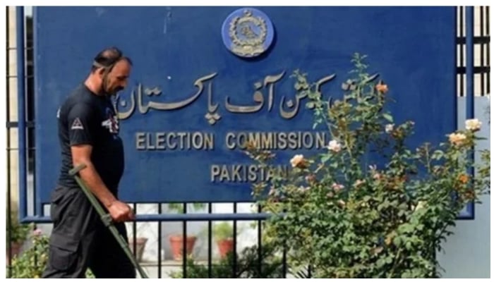 A guard and a signboard outside the Election Commission of Pakistan. — AFP/File