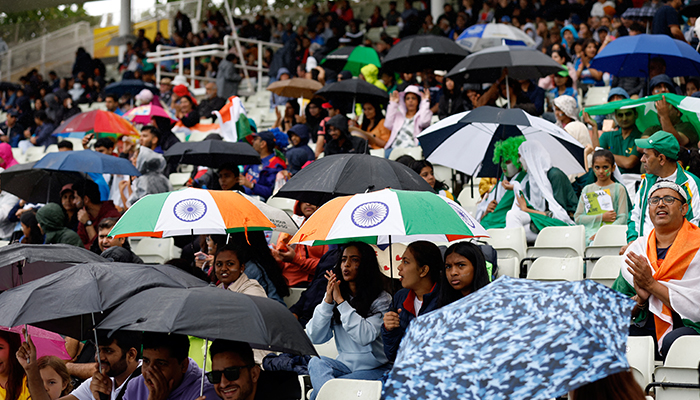 Commonwealth Games - Kriket Wanita T20 - Grup A - Pakistan v India - Stadion Edgbaston, Birmingham, Inggris - 31 Juli 2022 Fans dengan payung terlihat saat pertandingan ditunda karena hujan.  — Reuters