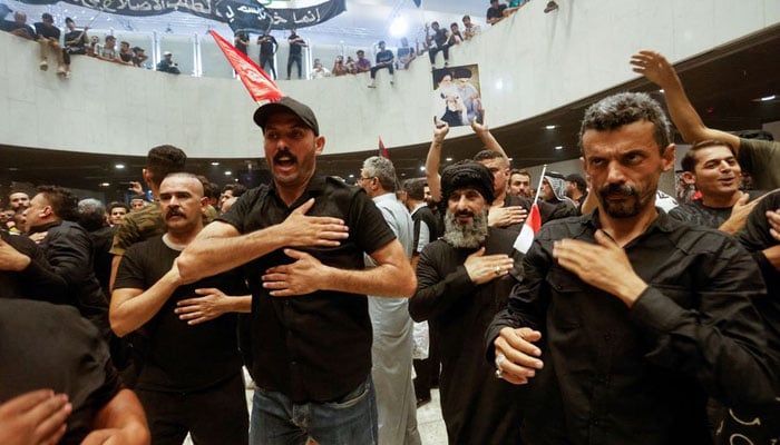 Supporters of Iraqi Shiite cleric Moqtada al-Sadr hit themselves in remembrance of Imam Hussein during a protest against corruption, inside the Parliament, in Baghdad, Iraq July 30, 2022.—Reuters