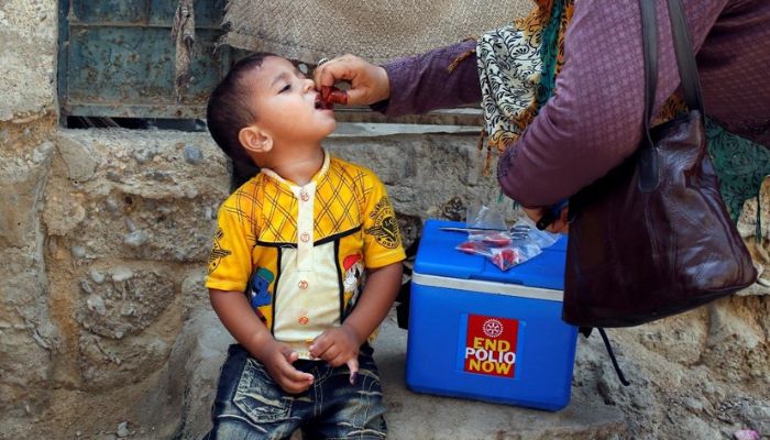 Health worker in Pakistan giving polio drops to a child - Reuters