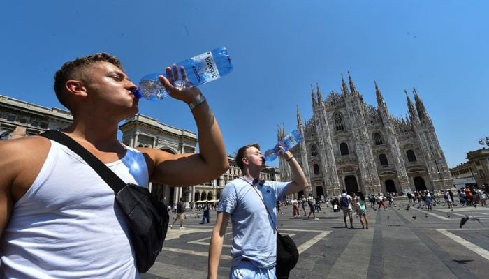 Men drink water by the Milans Duomo cathedral at Duomo square, as temperatures soar during a heatwave in Milan, Italy, July 21, 2022. — Reuters