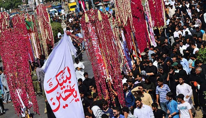 Mourners hold religious flags as they march in a procession on Muharram 8 in Karachi. Photo: AFP/File