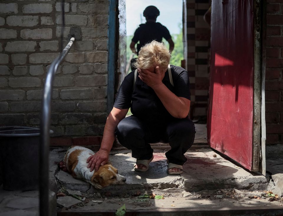 58 سالہ لینا، 9 جولائی 2022 کو یوکرین کے کوسٹیانتینیوکا میں، روسی فوجی حملے کے دوران اپنے شدید زخمی ہونے والے کتے ہیرا کے قریب ردعمل ظاہر کر رہی ہے۔