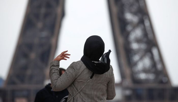 A woman wearing a hijab walks at Trocadero square near the Eiffel Tower in Paris, France, May 2, 2021. — Reuters