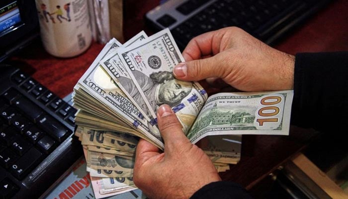 A money changer counts U.S. dollar banknotes at a currency exchange office in Ankara, Turkey November 11, 2021. — Reuters/File