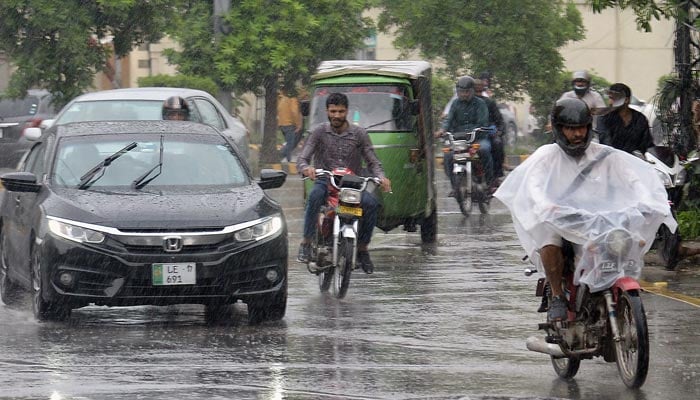 Commuters make their way during heavy rain in Lahore. — Online