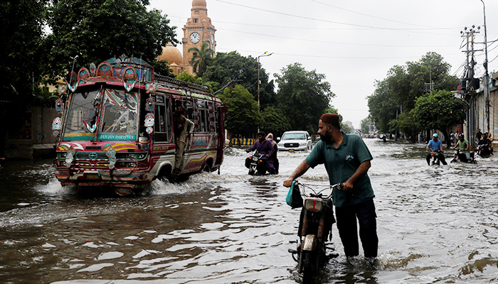 Residents commute through a flooded street, following heavy rains during the monsoon season in Karachi, Pakistan July 25, 2022. — Reuters