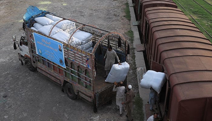 5 اگست 2022 کو پاکستان کے پشاور میں بلوچستان میں سیلاب متاثرین کے لیے کارکن امدادی سامان کی بوریاں لوڈ کر رہے ہیں۔ — رائٹرز