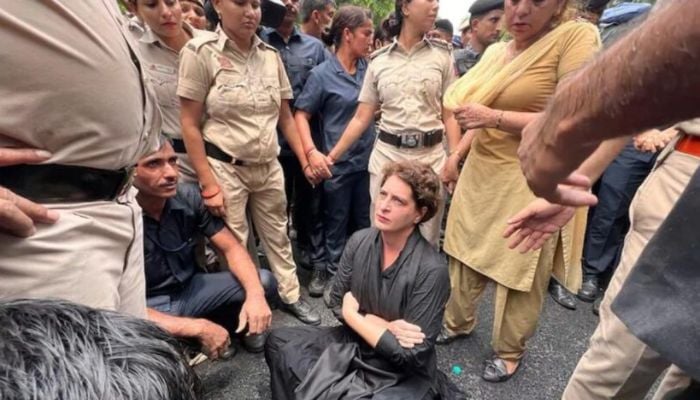 Priyanka Gandhi sits in protests surrounded by police. — Screengrab via Twitter