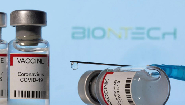 Vials labelled VACCINE Coronavirus COVID-19 and a syringe are seen in front of a displayed BioNTech logo in this illustration taken December 11, 2021. — Reuters