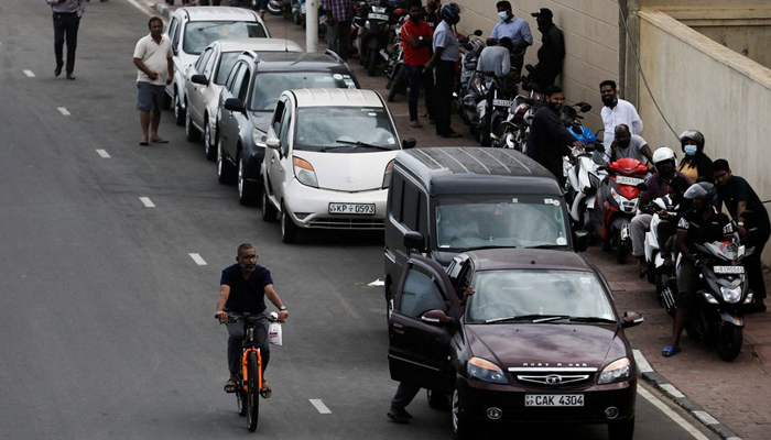 A man rides a bicycle passing a petrol queue due to major fuel shortage, amid the countrys economic crisis, in Colombo, Sri Lanka, July 5, 2022. — Reuters
