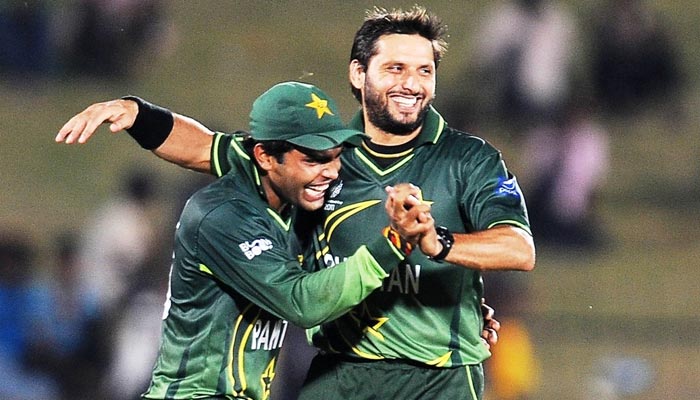 Pakistani wicketkeeper-batter Umar Akhmal (L) and former skipper Shahid Afridi celebrate after latter grabbed a wicket. — AFP/File