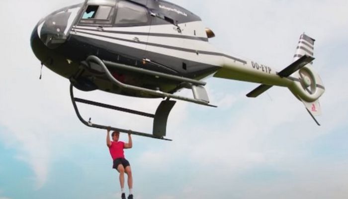 Stan Browney performs pushups dangling from a helicopter. Photo: Screengrab via YouTube