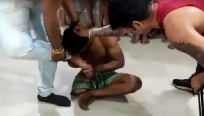 Disabled man forced to lick feet in Odisha, India. Photo: Screengrab via Twitter