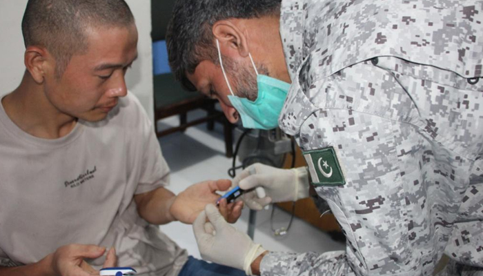 Chinese national,Zuo Xiang Wei, (left) being provided medical assistance by thePakistan Maritime Security Agency in Karachi, on August 10, 2022. — PMSA