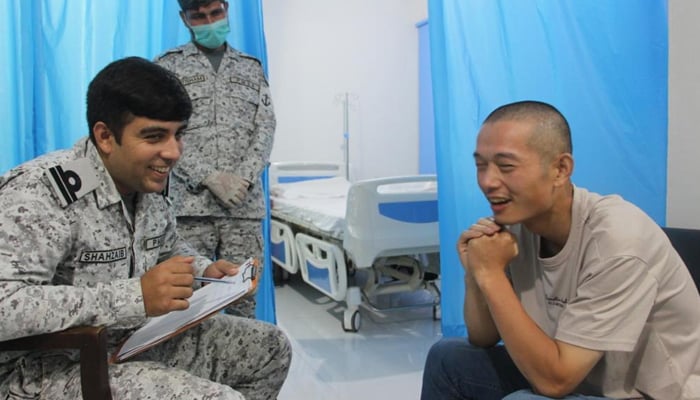 Chinese national, Zuo Xiang Wei, (right) speaks to an official of the Pakistan Maritime Security Agency in Karachi, on August 10, 2022. — PMSA