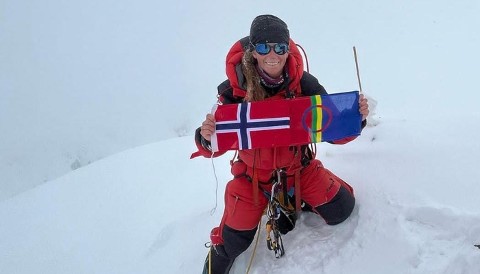 Norwegian mountaineer Kristin Harila holds her countrys flag while posing on top of a mountain in this undated photo. — Provided
