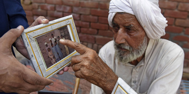 2 اگست 2022 کو لی گئی اس تصویر میں بھارتی سکھ مزدور سیکا خان اپنے بڑے بھائی صادق کو دکھا رہے ہیں۔  - اے ایف پی