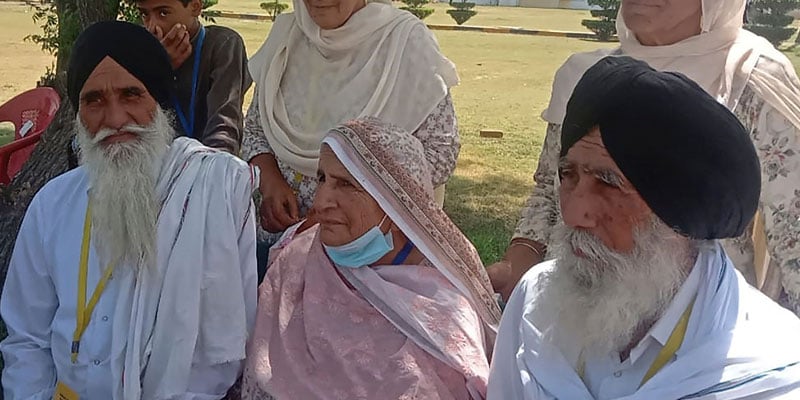 Pakistani woman Mumtaz Bibi (C, bottom) sitting with her Indian brothers Baldev Singh (L) and Gurmukh Singh (R) at the Kartarpur Corridor. — AFP