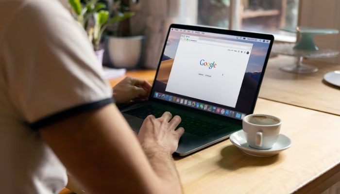 Man uses Apple MacBook in a cafe, searching Google website.— Unsplash