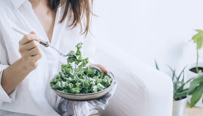 Woman eating Kale salad.— Unsplash