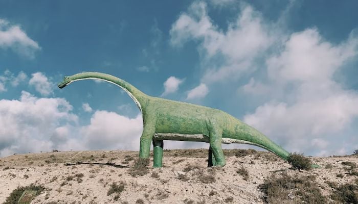 A representational image of a small green dinosaur. — Unsplash