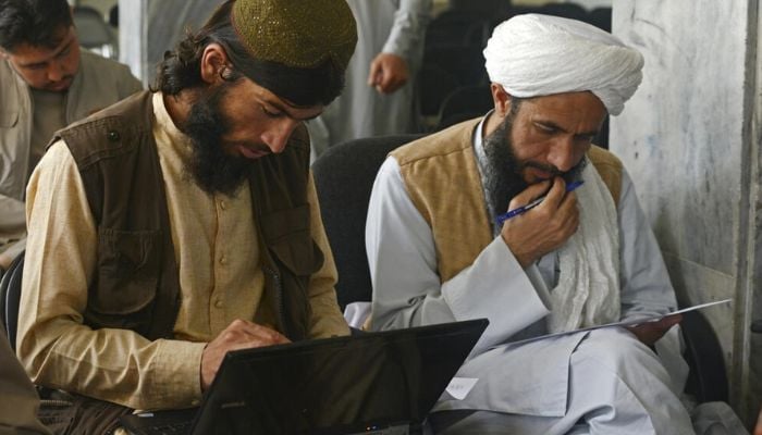 Taliban member Gul Agha Jalali (L) is one of many fighters who have traded combat for the classroom following the groups return to power. — AFP