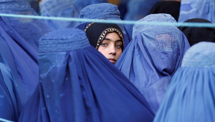 A girl looks on among Afghan women lining up to receive relief assistance, during the holy month of Ramadan in Jalalabad, Afghanistan, June 11, 2017. — Reuters/File