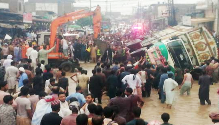 Rescue works underway after truck falls over a passenger bus in Rahim Yar Khans Feroza area, on August 13, 2022. — Twitter