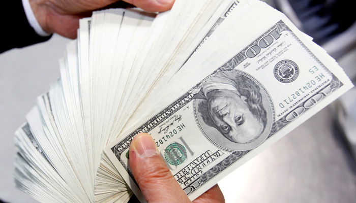 An employee of the Korea Exchange Bank counts one hundred US dollar notes during a photo opportunity at the banks headquarters in Seoul April 28, 2010. — Reutrers