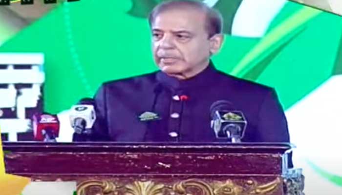 Prime Minister Shehbaz Sharif addresses a national flag-hoisting and unveiling of re-recording ceremony of the national anthem here at the Jinnah Convention center in Islamabad. Photo: Geo News/screengrab