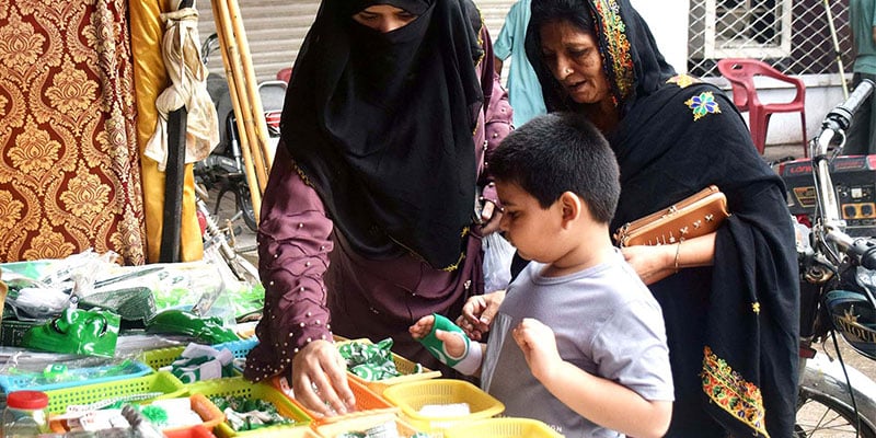 A child selects independence day themed items from a stall. — INP