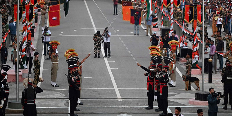 پاکستانی رینجرز (سیاہ رنگ میں) اور ہندوستانی بارڈر سیکورٹی فورس (BSF) کے سپاہی پاک بھارت واہگہ بارڈر پوسٹ پر پاکستان کے 75 ویں یوم آزادی کی تقریبات کے دوران بیٹنگ دی ریٹریٹ تقریب میں حصہ لے رہے ہیں۔  - اے ایف پی