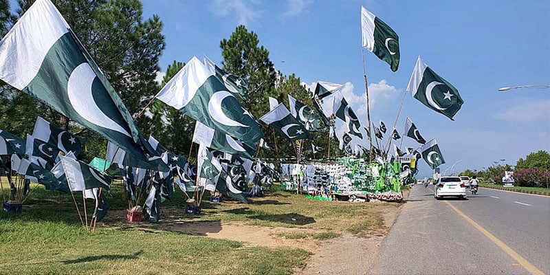 Green flags flutter with wind at a stall. — PPI