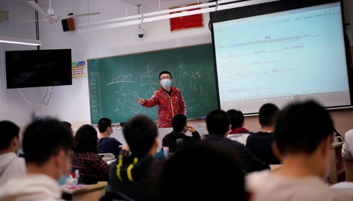 A teacher wearing a face mask teaches inside a classroom during a government-organised media tour at a high school as more students returned to campus following the coronavirus disease (COVID-19) outbreak, in Shanghai, China May 7, 2020. — Reuters