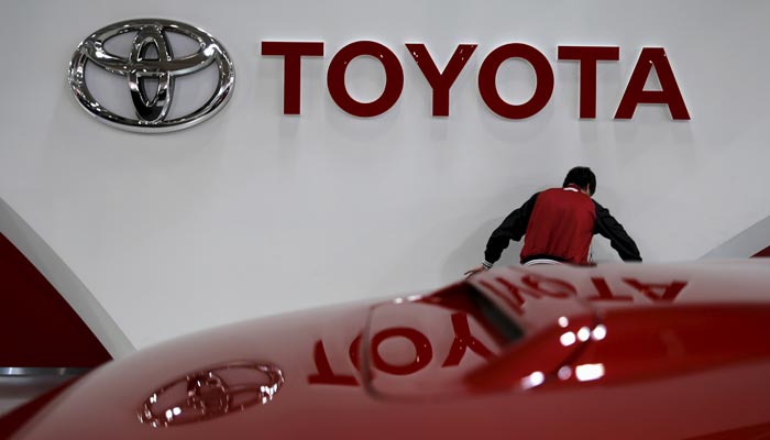 An employee works under a Toyota Motor Corp logo at the companys showroom in Tokyo, Japan February 5, 2016. — Reuters/File