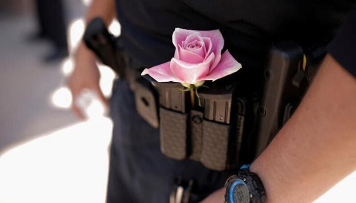 An officer from the Albuquerque Police Department wears a rose next to his gun magazines during a unity event against sectarian hate following the murders of four Muslim men in Albuquerque, New Mexico, US, August 12, 2022. — Reuters